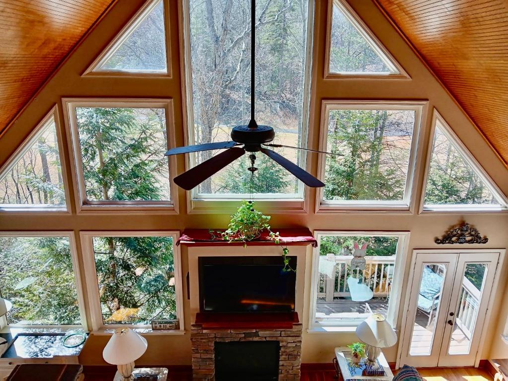 a living room with a ceiling with windows and a tv at Chalet Suzanne in Helen