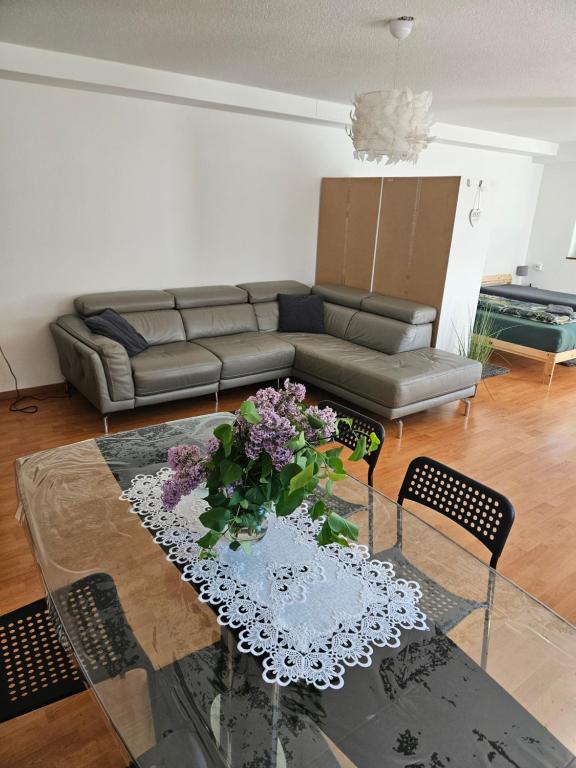 a living room with a couch and a table with flowers at Premium Home 2 in Busingen am Hochrhein