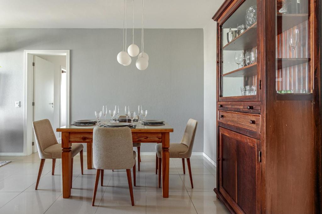 a dining room with a wooden table and chairs at Apt Boutique Grande Florianópolis - Sua Estadia SC in São José