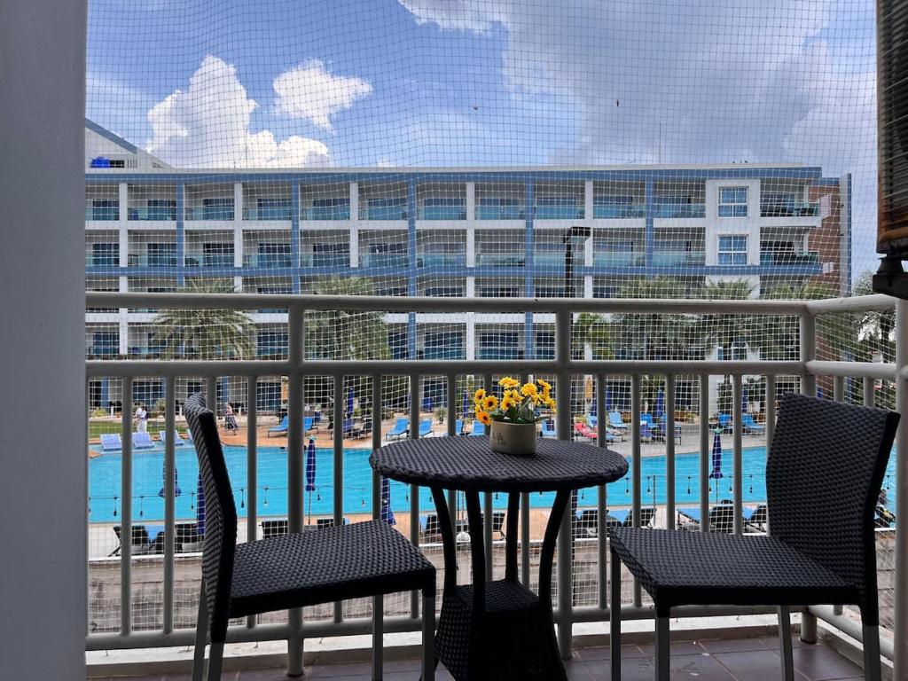 a table and chairs on a balcony with a pool at Mae Phim beach in Ban Tha Fat