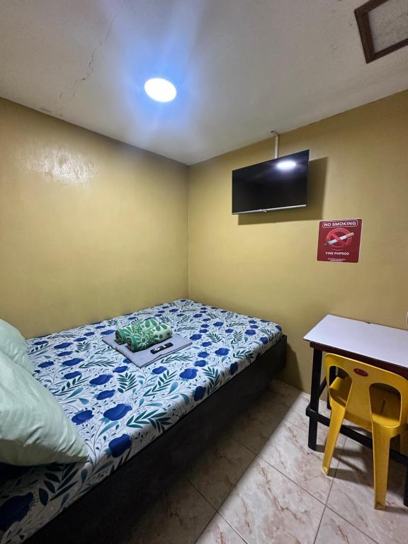 a small bedroom with a bed and a table at Don Pedro in Tacloban