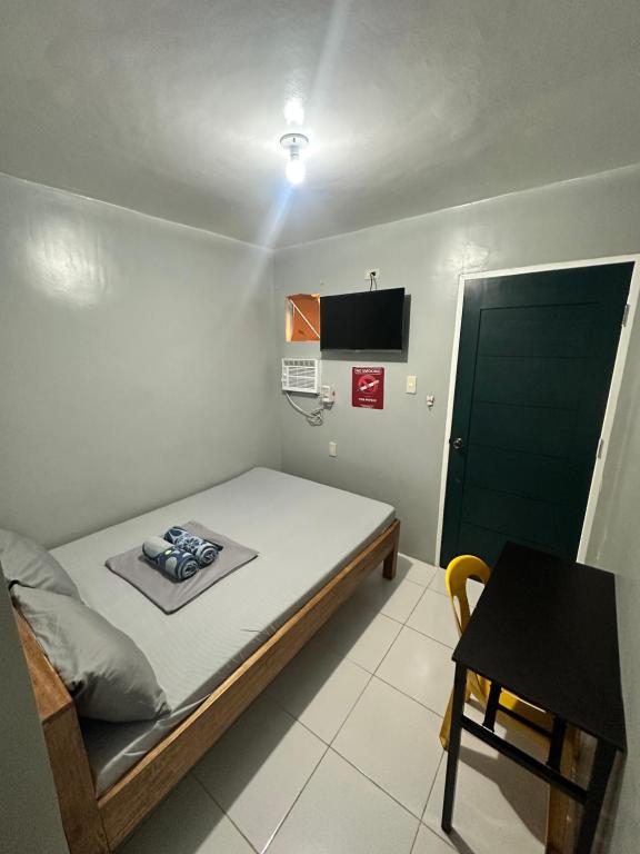 a small bedroom with a bed and a table at Don Pedro Deluxe 2 in Tacloban