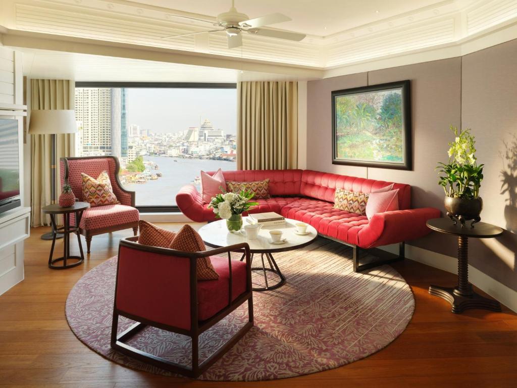 A red upholstered living room with a river-and-city outlook.