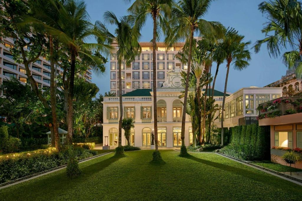 an exterior view of a building with palm trees at Mandarin Oriental, Bangkok in Bangkok