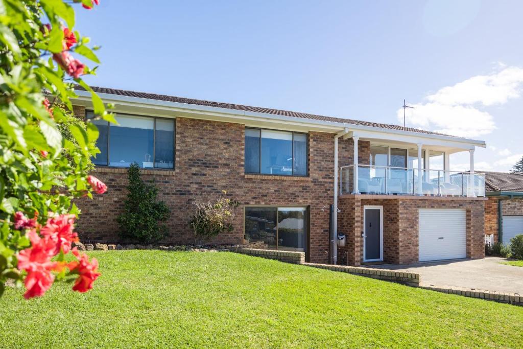 a brick house with a lawn in front of it at Rundle & Salt in Ulladulla