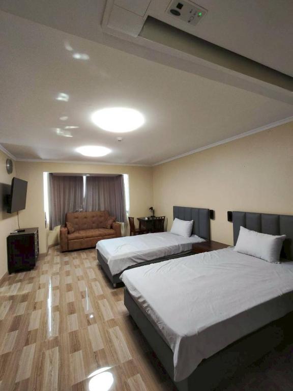 a hotel room with two beds and a couch at omni1818 in Bang Kapi