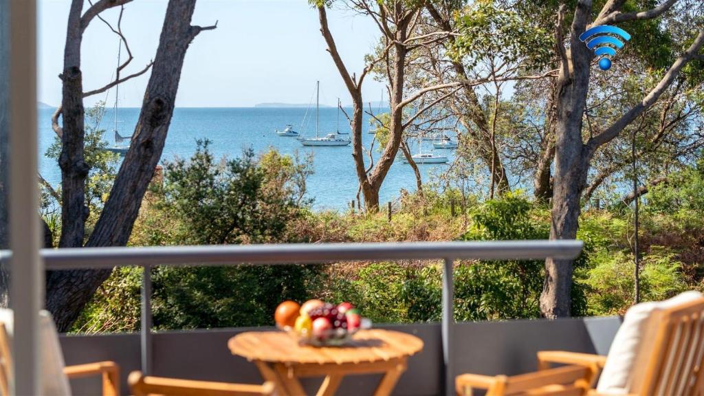 a balcony with a table with a view of the water at Lucys at the Bay in Callala Bay