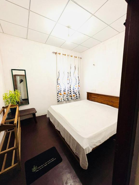 a bedroom with a large bed and a mirror at Oli Guest House in Diyatalawa