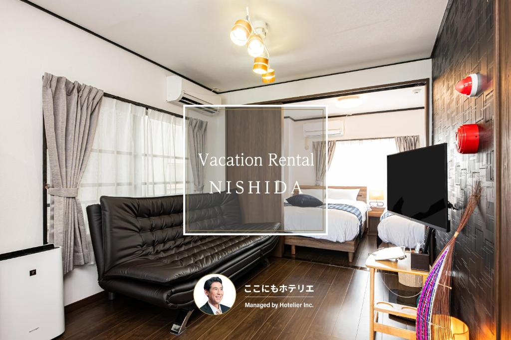 a bedroom with a black leather couch and a bed at Vacation Rental NISHIDA in Kagoshima