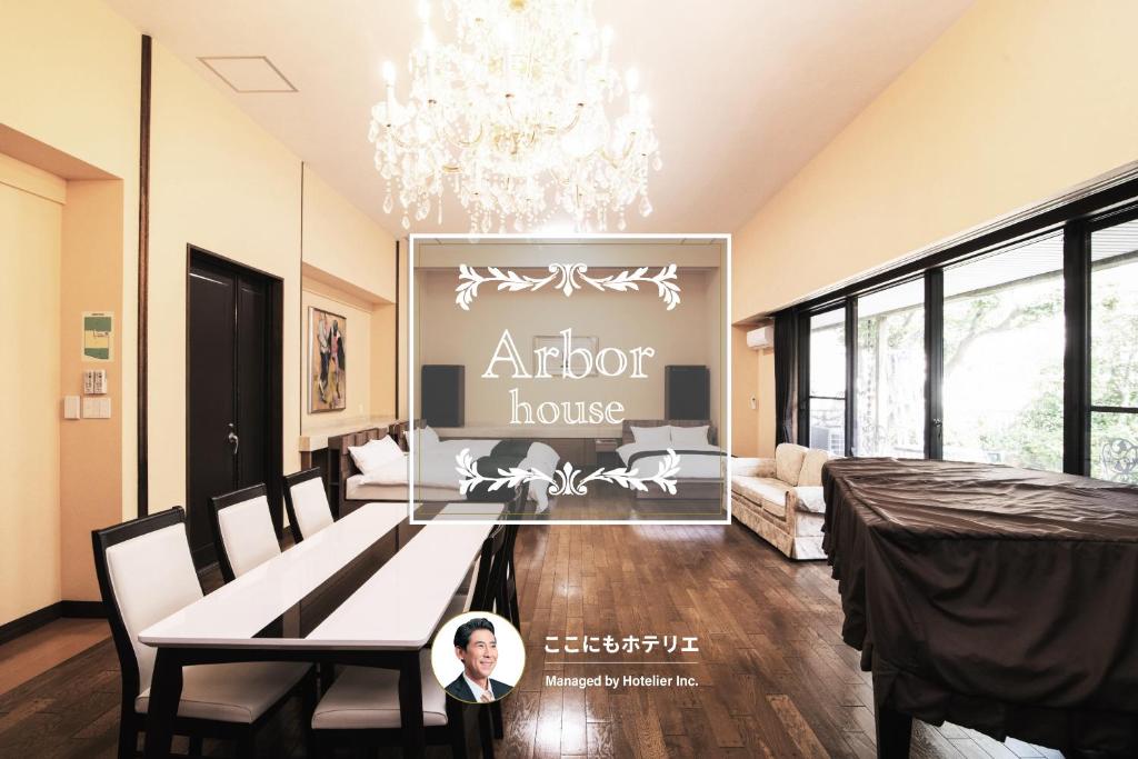 a living room with a table and a chandelier at Arbor house in Kagoshima