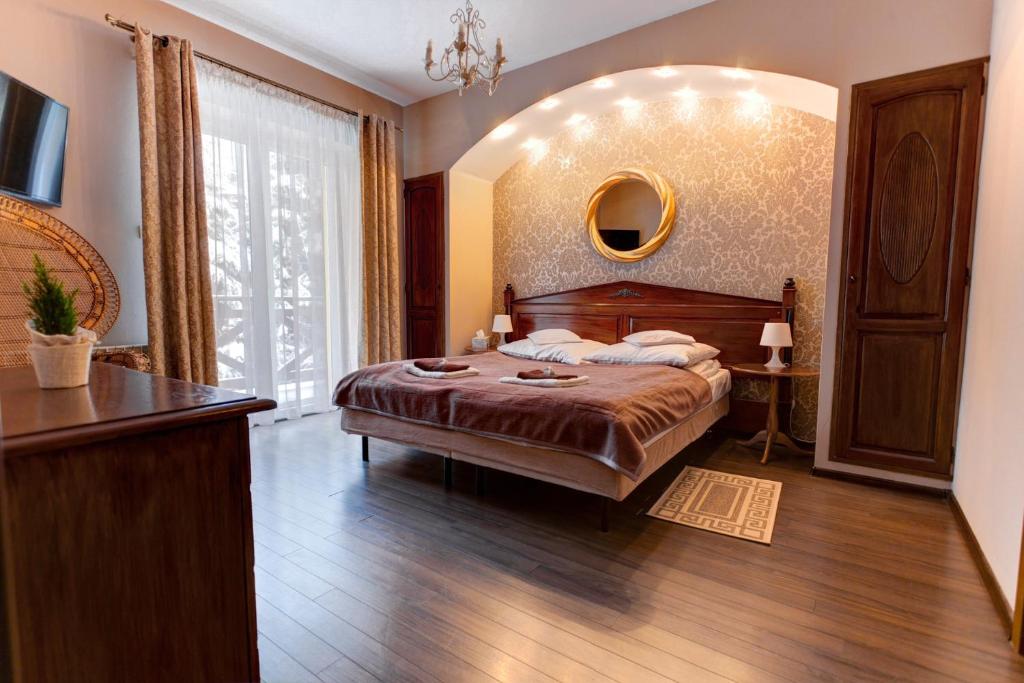 クリニツァ・ズドルイにあるWilla Lubicz Apartamenty Rodzinne w Krynicy Zdrojuのベッドルーム1室(ベッド1台、大きな窓付)