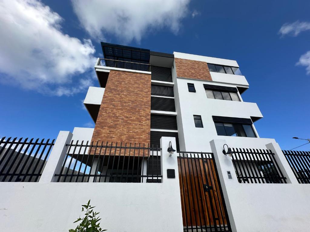 a tall white building with a brick chimney at Roys Suites Galapagos in Puerto Ayora