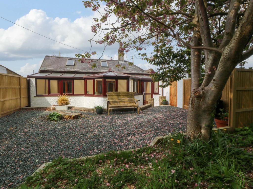 a house with a bench in a yard at Ty Taid in Gaerwen