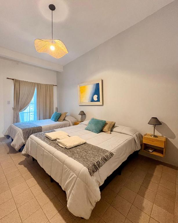 two beds in a large room with two lamps at Linas Apart & Suite in La Rioja