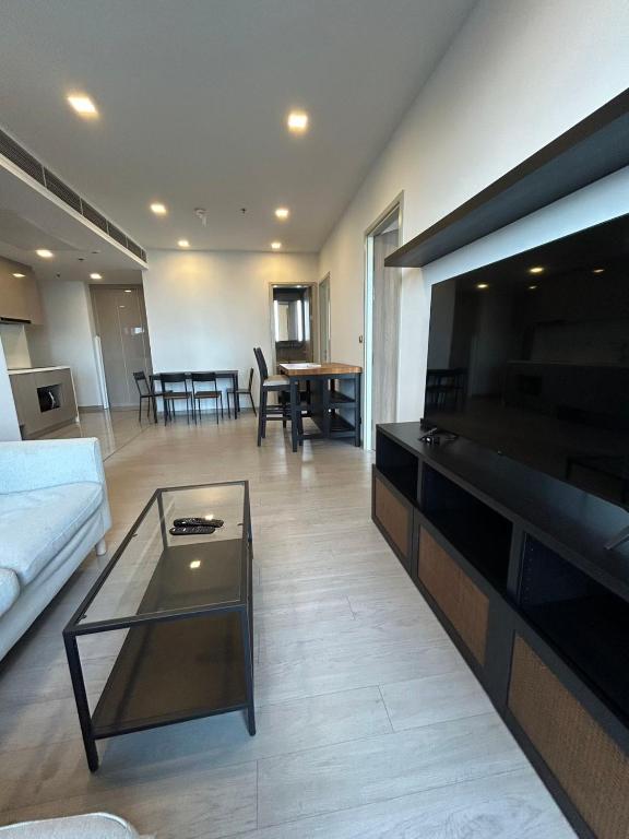 a living room with a couch and a large flat screen tv at One9Five Asoke 可月租 in Ban Hui Yai Muk