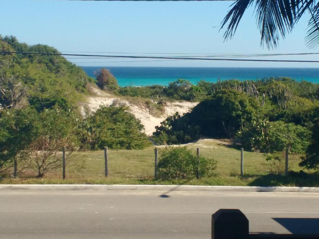 a view of the beach from the road at Casa 4 quartos Condomínio em Frente a Praia Grande in Arraial do Cabo