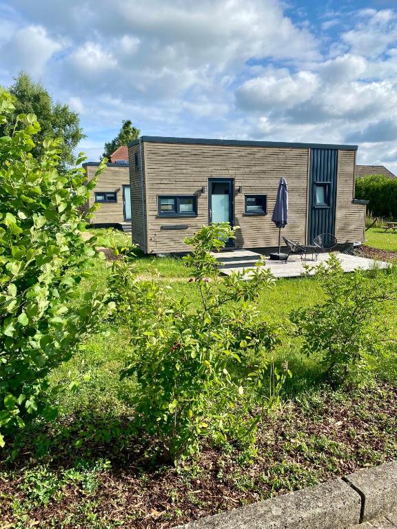 a small house with a umbrella in a yard at Tiny Om Ferienhaus in Laichingen