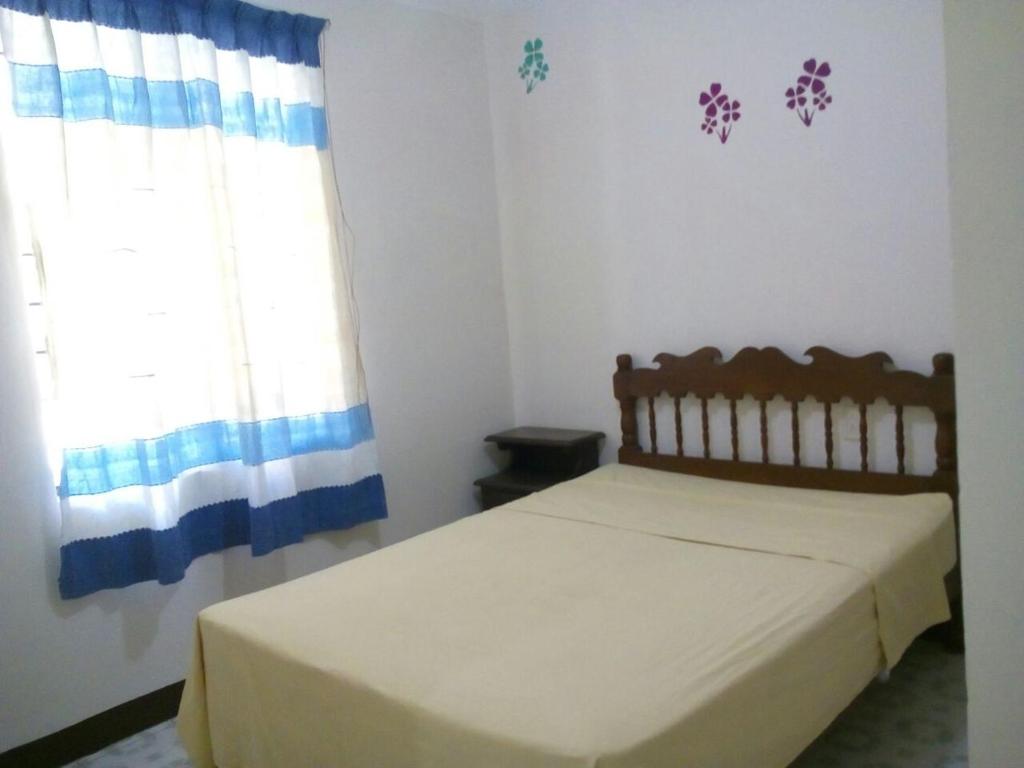 um quarto com uma cama e uma janela em Departamentos monumento em Oaxaca de Juárez