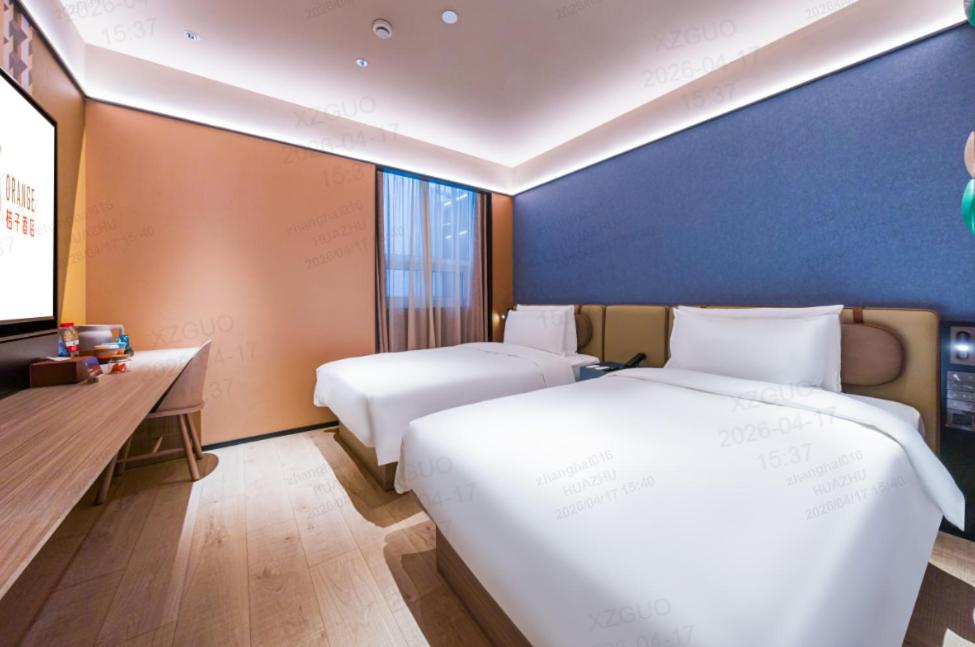 a hotel room with two beds and a tv at Orange Hotel Shanghai Wuzhong Road Metro Station in Shanghai