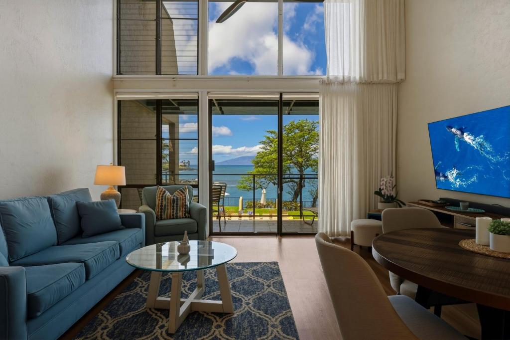 a living room with a blue couch and a table at Prime Oceanfront 2BR Loft - Unit C10 condo in Lahaina