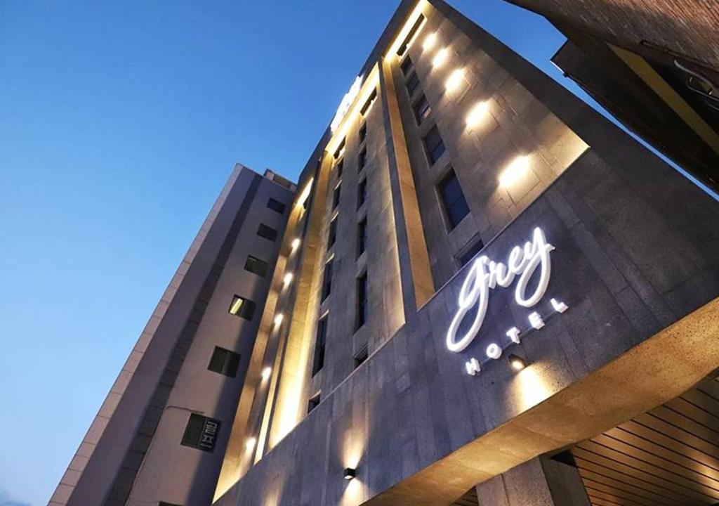 a building with a sign on the side of it at Gangneung Grey Hotel in Gangneung