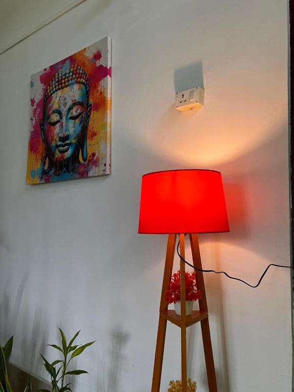 a red lamp sitting next to a wall with a painting at Green Stay,AC room in Sibsāgar