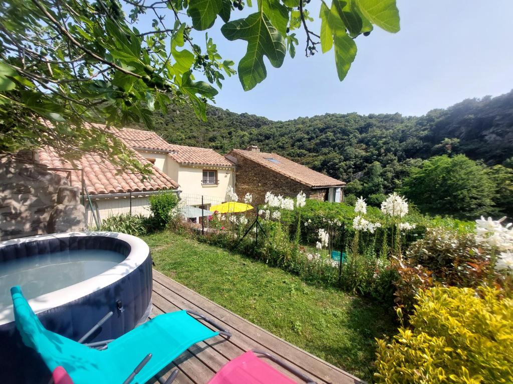 a view of a yard with a hot tub on a deck at La Fontchaude, gîte de charme au cœur de la nature à Cabrespine in Cabrespine