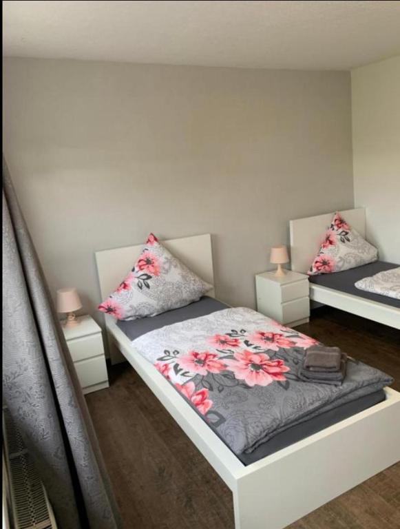 a bedroom with two beds and two night stands at Vina am Ring Apartment in Mannebach