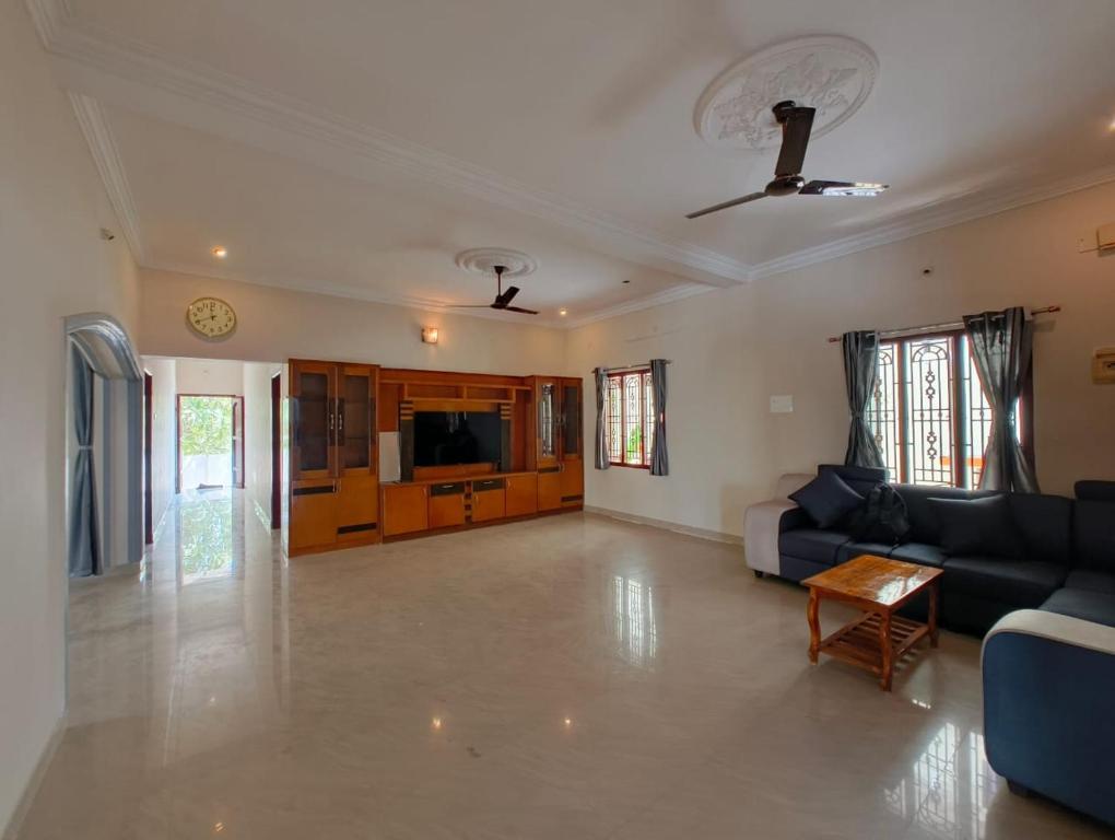 a large living room with a couch and a tv at Eesha Elite - Rameswaram in Rāmeswaram