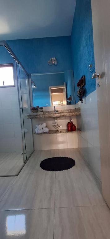a bathroom with a blue wall and a mirror at Moraes Residence in Belo Horizonte