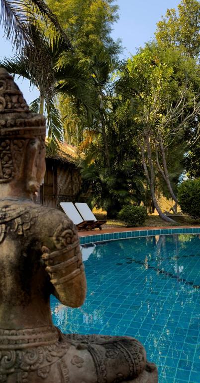a statue standing in front of a swimming pool at Sang Tong Huts in Mae Hong Son