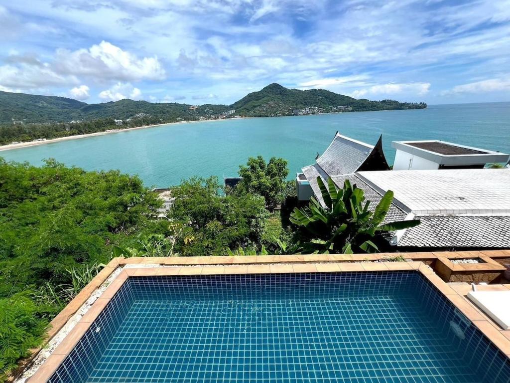 a swimming pool with a view of the ocean at Villa H in Surin Beach