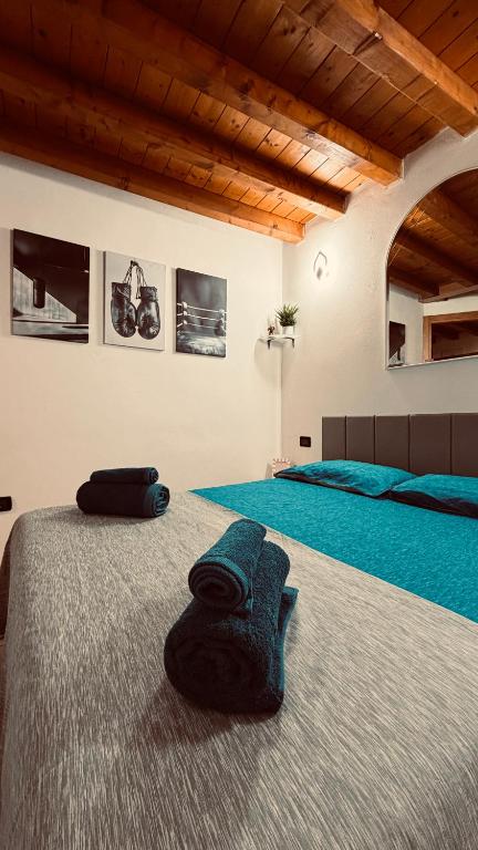 a bedroom with two beds with blue sheets at The Mastiffs in Chioggia