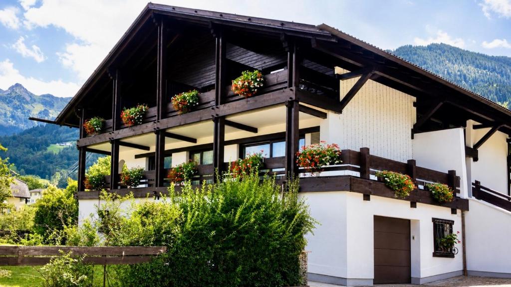 a house in the mountains with flowers on the balcony at Chalet Bodenschatz in Vandans