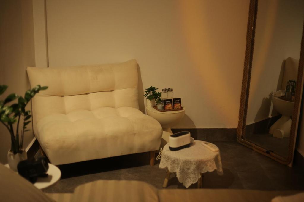 a living room with a white couch and a mirror at Behomestay in Hai Phong