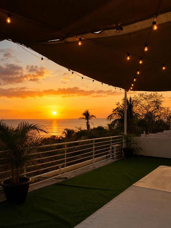 a sunset over the ocean from a marquee at Cocos House Zicatela in Puerto Escondido