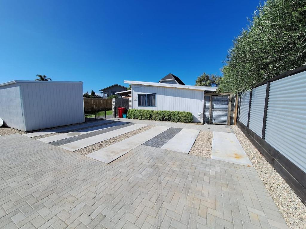 a backyard with a fence and a house at Beach Pad in Whangamata