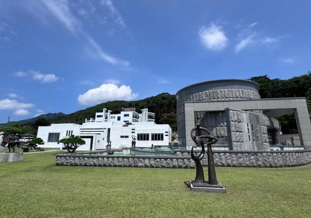 a building with a statue in front of it at HwiMokArt Resort in Buan