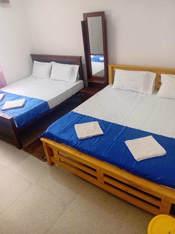 two beds sitting next to each other in a room at River View Inn in Maskeliya