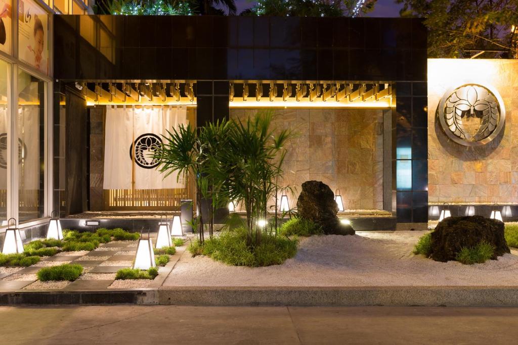 曼谷的住宿－Bandara Silom Suites, Bangkok，一座建筑,前方有种有植物的庭院