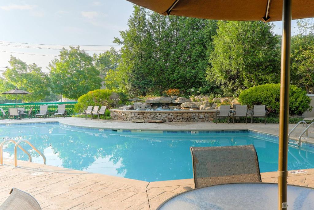 a swimming pool with chairs and a table and an umbrella at Quality Inn Near the Island Pigeon Forge in Pigeon Forge