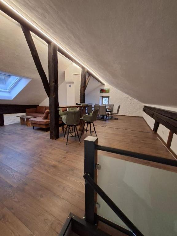 an attic room with a wooden floor and a table and chairs at Ferienhaus Wittmann in Beilngries