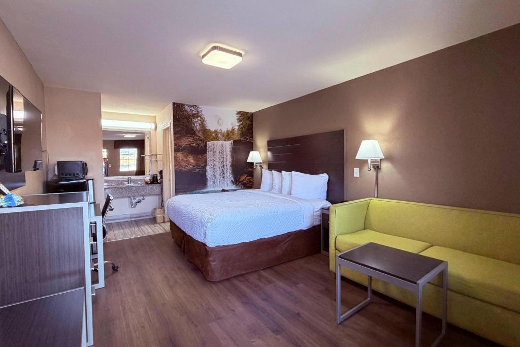 a hotel room with a bed and a couch at Clarion Pointe Athens I-65 in Athens