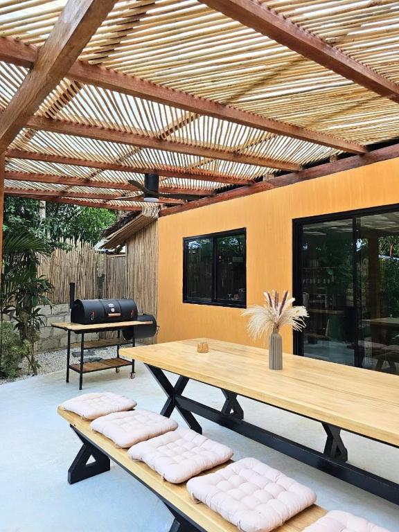 a patio with a wooden table and benches at Red Palm Villa in San Vicente