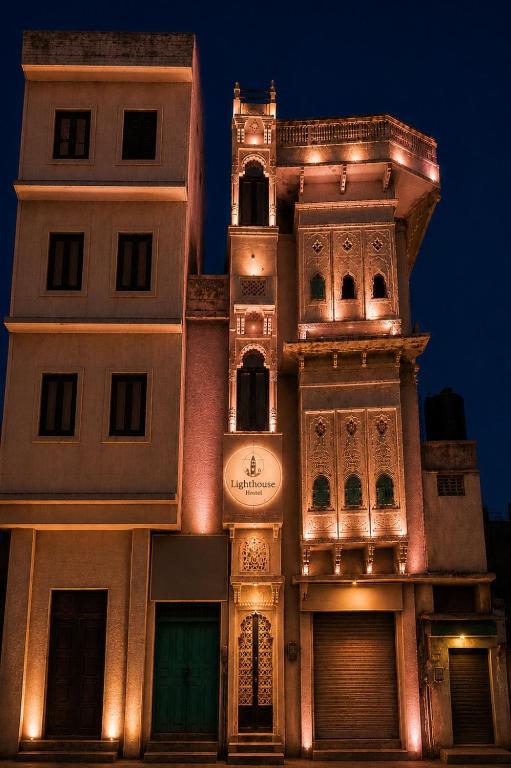 a tall building with a clock tower at night at Lighthouse Hostel in Udaipur
