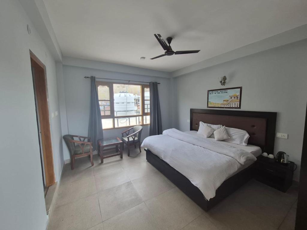 a bedroom with a bed and a table and chairs at Hotel Sidharth Tabo in Tabo