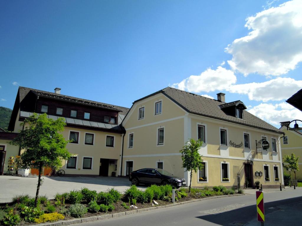 a large white building with a car parked in front at Zeit/-Los in Irdning