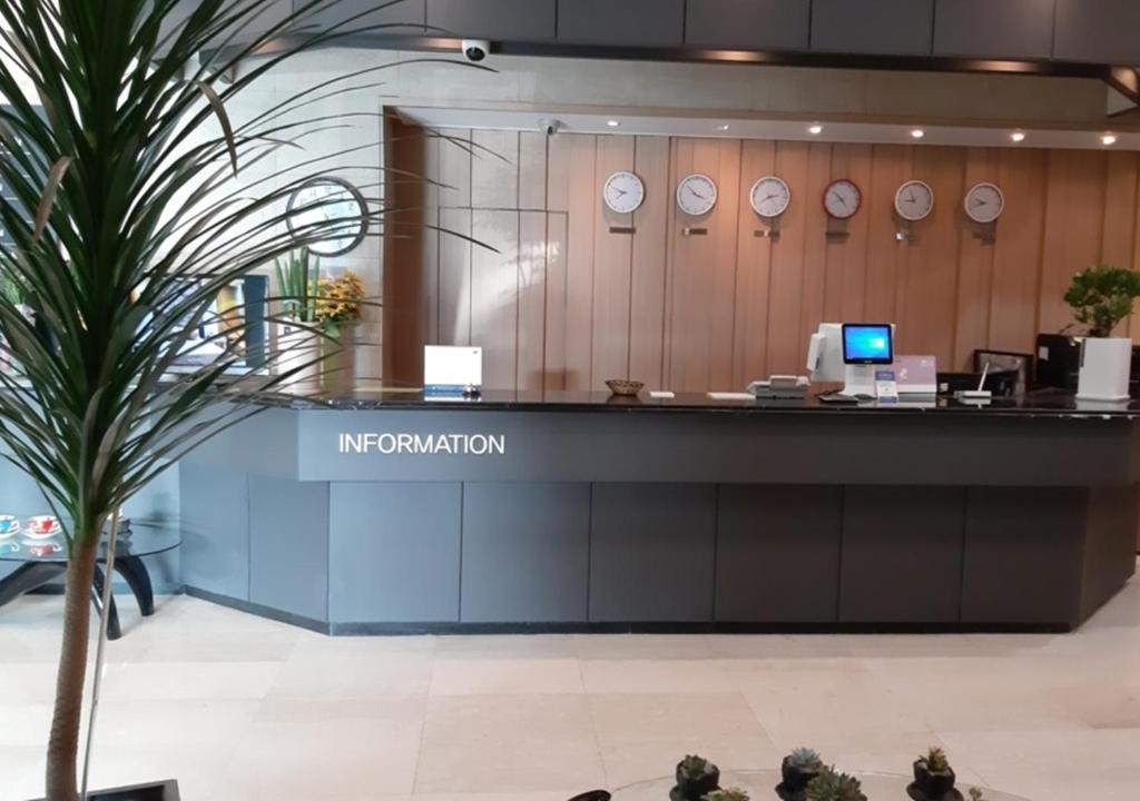 an immigration counter in an airport with clocks on the wall at Ansan Seowon Tourist Hotel in Ansan