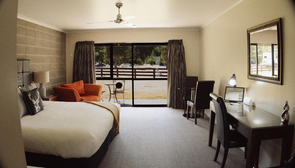 a hotel room with a bed and a desk and a desk at Lakeside by Ruataniwha in Twizel