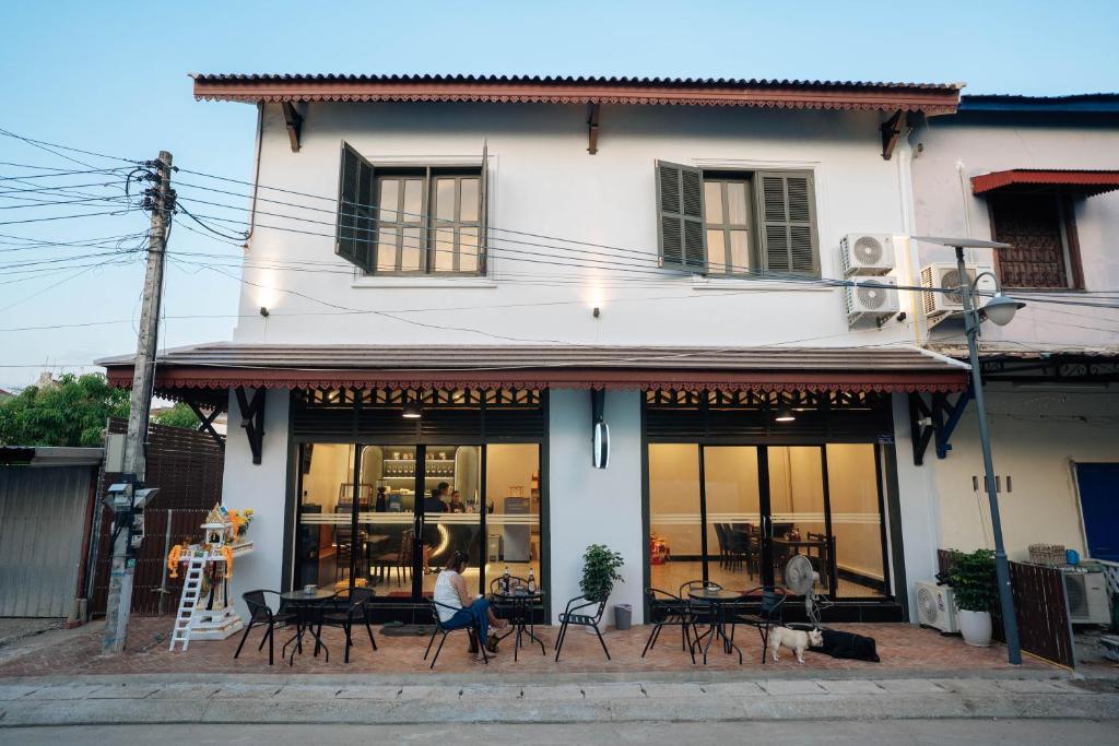 a building with tables and chairs in front of it at Nam Phou Hostel in Thakhek